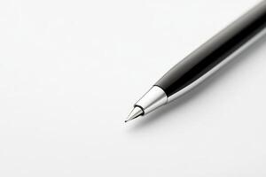 Close-up of a sleek black pen poised on clean white paper ready for writing photo