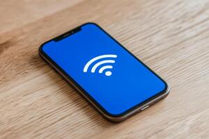 Mobile phone displaying a Wi-Fi symbol on a wooden surface during daytime photo
