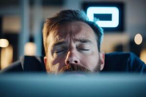 Focused man resting in front of computer during late night programming session in a home office photo
