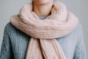 Soft knitted scarf worn on a cozy sweater during a calm indoor setting in autumn season photo