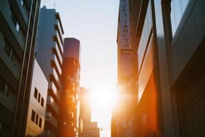 Urban sunset viewed between tall buildings with warm light casting shadows in the late afternoon sky photo