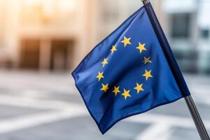 Blue European Union flag waving in the breeze with soft sunlight in the background in an urban setting photo