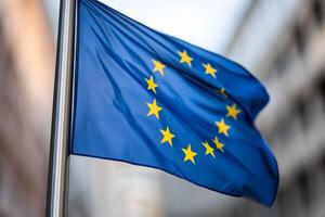 European Union flag waving against a blurred urban backdrop on a sunny day photo