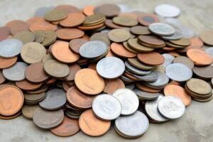 Large collection of coins spread across a surface showcasing diverse currencies and denominations photo