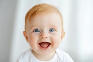 Happy baby with bright blue eyes smiles joyfully in front of a light background during a cozy indoor moment photo