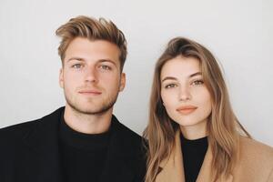 Young couple posing together in a stylish indoor setting with neutral background photo