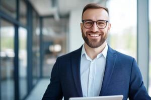 Confident business professional smiling while holding a tablet in a modern office setting during daylight hours photo