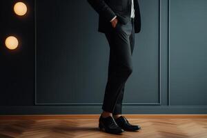 Elegant man dressed in formal attire stands confidently against a dark wall in a stylish indoor setting photo