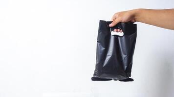 Hand Shows Black Blank Plastic Bag Mock Up on White Background photo