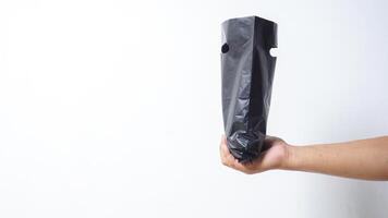 Man Hand Holding Open Black Plastic Bag on White Background photo