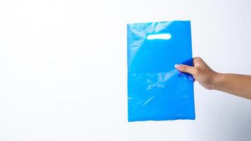 Hand Holding Blue Disposable Plastic Bag Mock Up with Handle on White Background photo