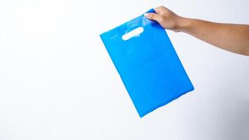 Hand Holding Blue Plastic Bag Mock Up with Handle on White Background photo