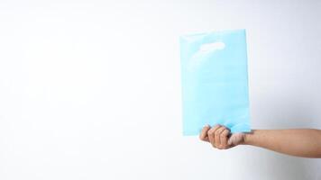 Hand Showing Blank Light Blue Plastic Bag with Handle on White Background photo