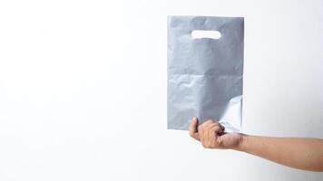 Hand Carrying Empty Blank Gray Plastic Bag Mock Up on White Background photo