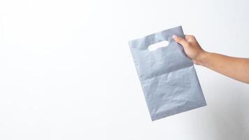 Hand Holding Empty Gray Plastic Bag on White Background photo