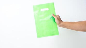 Hand Holding Green Plastic Bag Mock Up on White Background photo