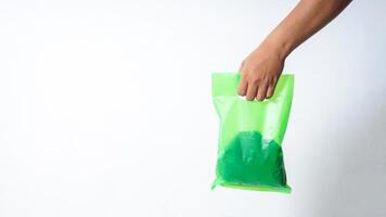 Hand Carrying Green Plastic Bag Mock Up on White Background photo