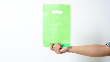 Hand Shows Green Plastic Bag Mock Up with Handle on White Background photo