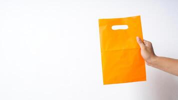Hand Showing Blank Orange Plastic Bag Mock Up with Handle on White Background photo