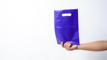 Hand Shows Blank Purple Plastic Bag Mock Up with Copy Space on White Background photo