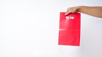 Hand Carrying Red Pink Plastic Bag Mock Up on White Background photo