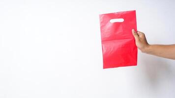Hand Holding Blank Red Pink Plastic Bag Mock Up with Copy Space on White Background photo