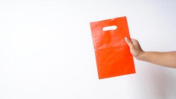 Hand Showing Blank Red Plastic Bag Mock Up on White Background photo