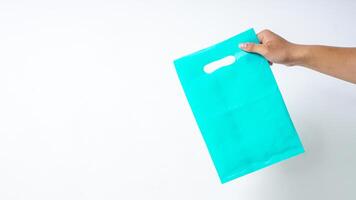 Hand Holding Turquoise Plastic Bag Mock Up on White Background photo