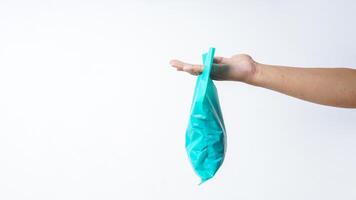 Side View of Hand Carrying Turquoise Plastic Bag with Copy Space on White Background photo