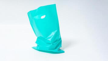Empty Open Turquoise Plastic Bag on White Background photo