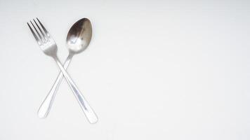 Stainless steel spoon and fork with copy space isolated on white background photo