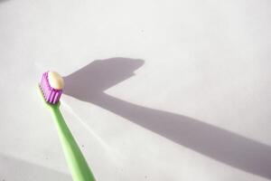 Toothbrush with toothpaste casting a sharp shadow photo