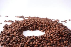Roasted coffee beans arranged in a circle on white background photo