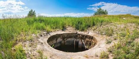 A hole in the ground with grass and dirt photo
