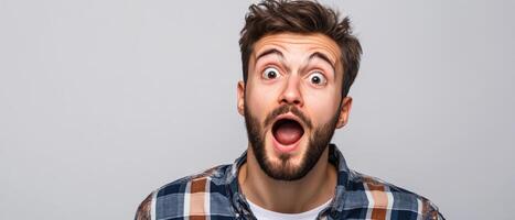 Portrait of a surprised man with open mouth isolated on gray background photo