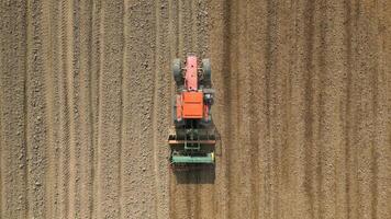 Top view of tractor sowing grain in the farm field. video