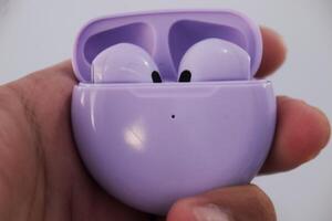 Close-Up of Purple Wireless Earbuds in Charging Case photo