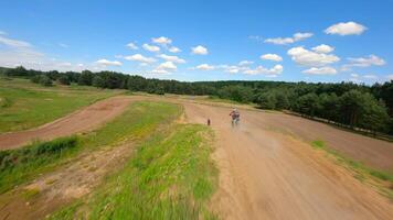 Dynamic FPV shot of racers on motocross bikes on the track at high speed. video