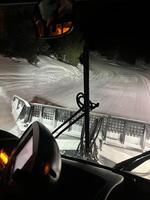 Snowplow clearing snow at night on mountain road photo