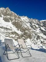 Relaxing deck chairs enjoying breathtaking view of snow capped Mont Blanc massif in Courmayeur, Italy photo