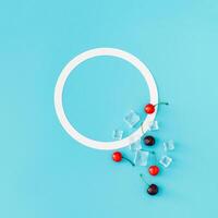 Trendy summer composition made of red cherries and ice cubes on light blue background with copy space. Flat lay summertime drink minimal concept. Cherry fruit aesthetic. Top view banner. photo