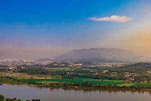 An aerial view of the skyline of Chiang Saen, with mountains in the background and the river that separates the two countries. photo