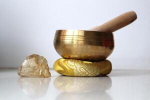 Singing bowl and citrine crystal on the table. Sound healing. Alternative therapy and relaxation. photo