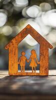 Wooden house silhouette with family cutout, symbolizing love and unity photo