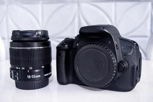 A DSLR camera and a standard zoom lens with focal length range 18-55 mm. photo