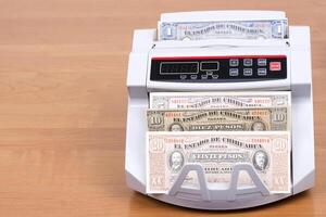 Old mexican peso in a counting machine photo