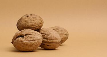Stack of walnut fruits on brown background photo