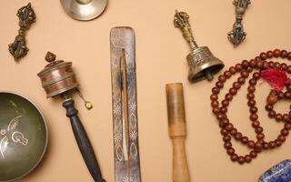 Tibetan singing copper bowl with a wooden clapper on a brown background, objects for meditation and alternative medicine, top view photo