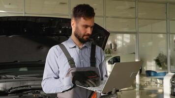 Auto mechanic using laptop for car diagnostics in workshop video