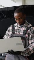 Auto mechanic using laptop for car diagnostics in workshop video